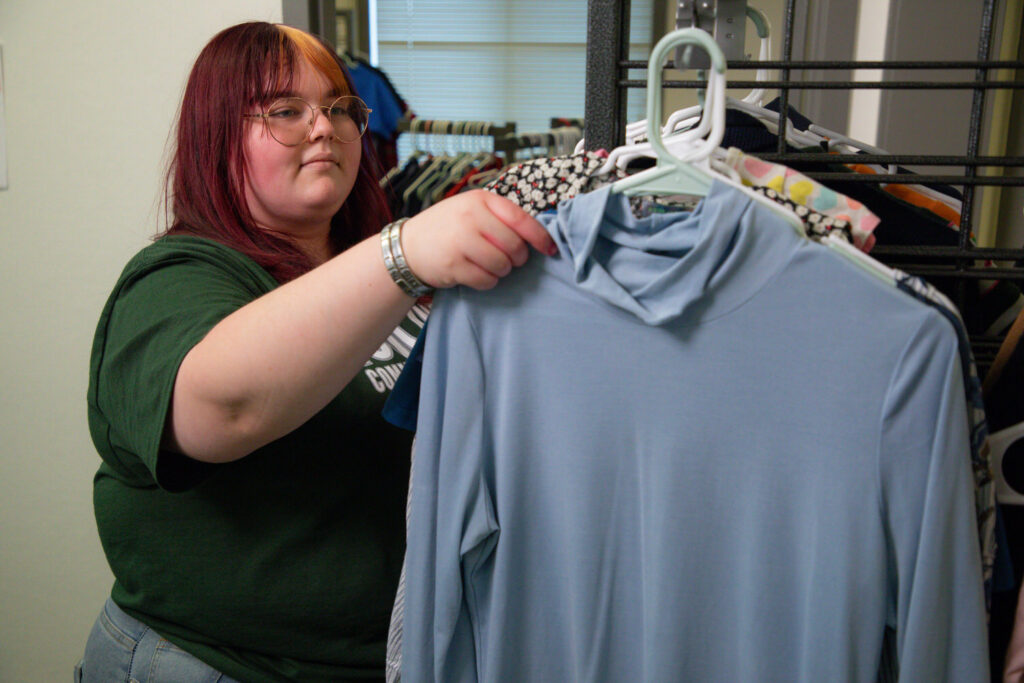 Student selecting from shirts and other basic needs items at Lake County Campus