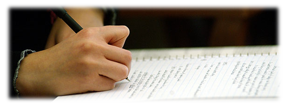 Student's hand holding a pen writing notes in a spiral notebook