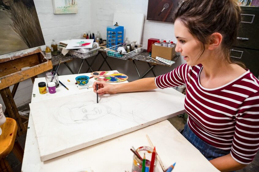 Woman sketching a drawing on canvas
