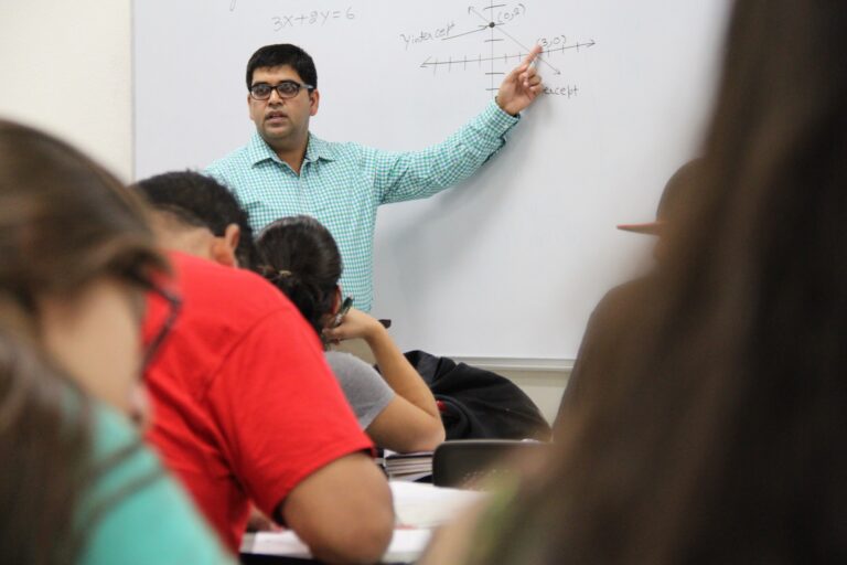 math instructor pointing to whiteboard