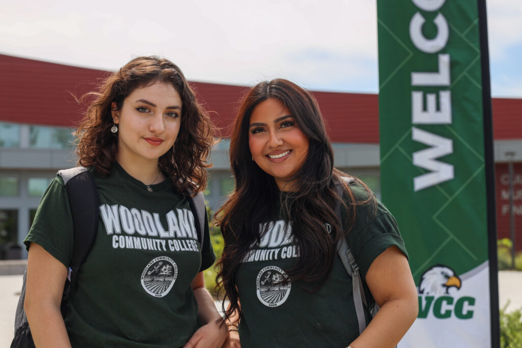 two students smiling with WCC shirts at welcome event